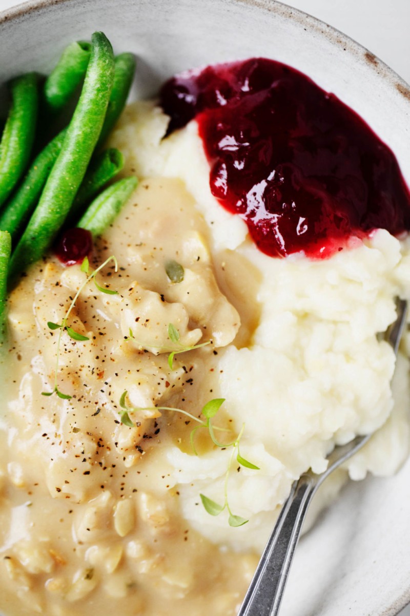 A cozy, hearty serving of traditional Thanksgiving ingredients, garnished with fresh thyme.