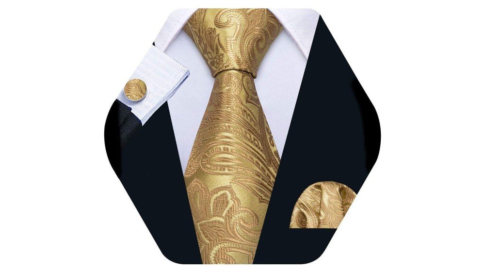 A gold paisley men's necktie with a white collared shirt, suit coat, and matching pocket square