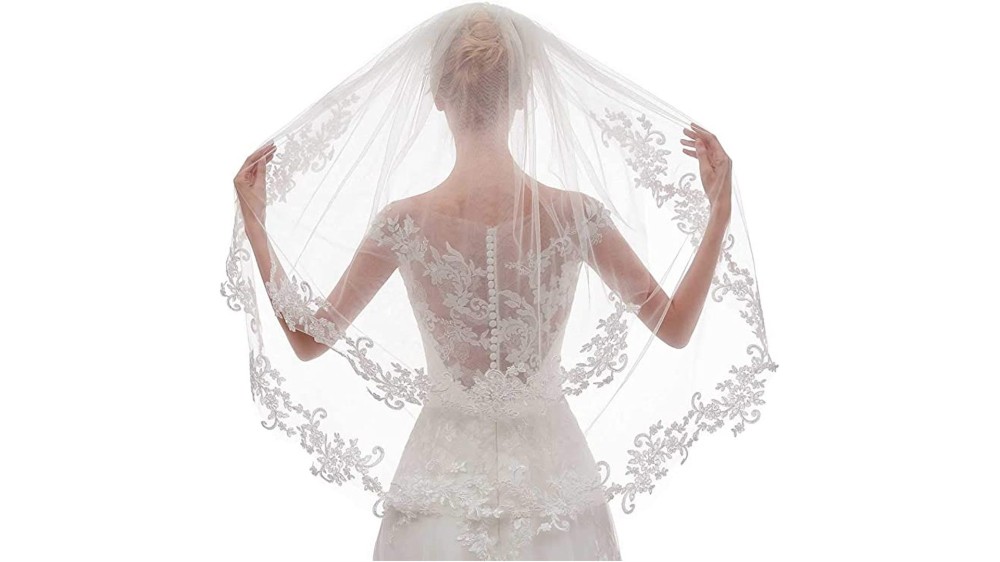 back view of bride displaying wedding veil with patterned floral lace edges