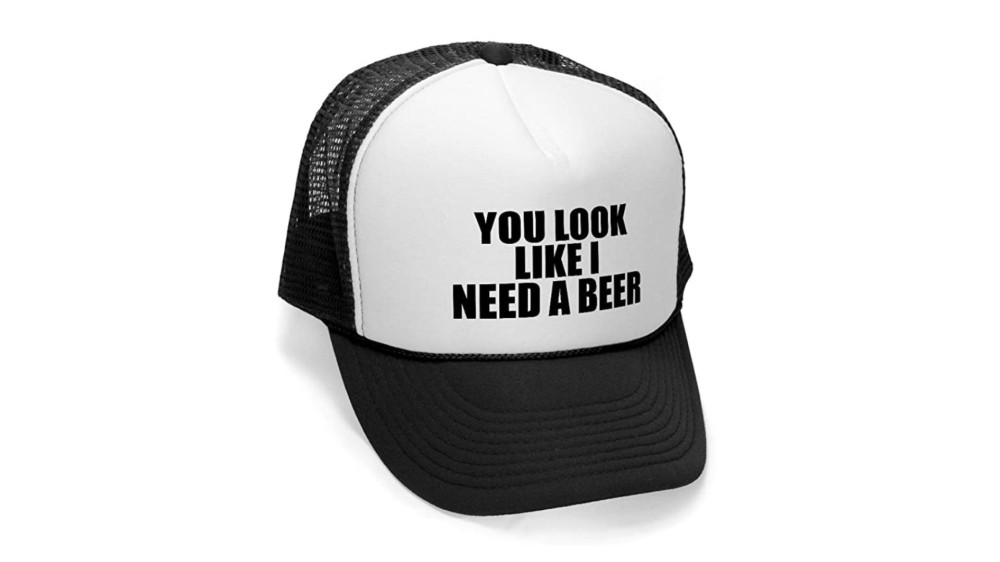 A white and black hat that says "You Look Like I Need A Beer" on the front.