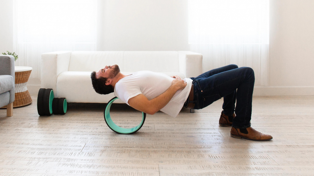 Man stretching on yoga wheel