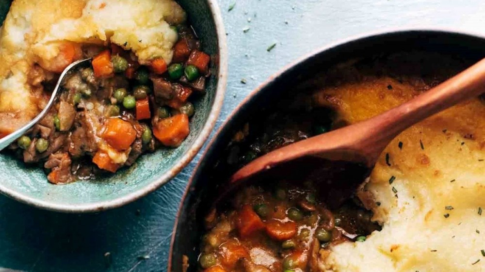 A casserole dish and bowl full of vegetarian Shepherd's pie. 