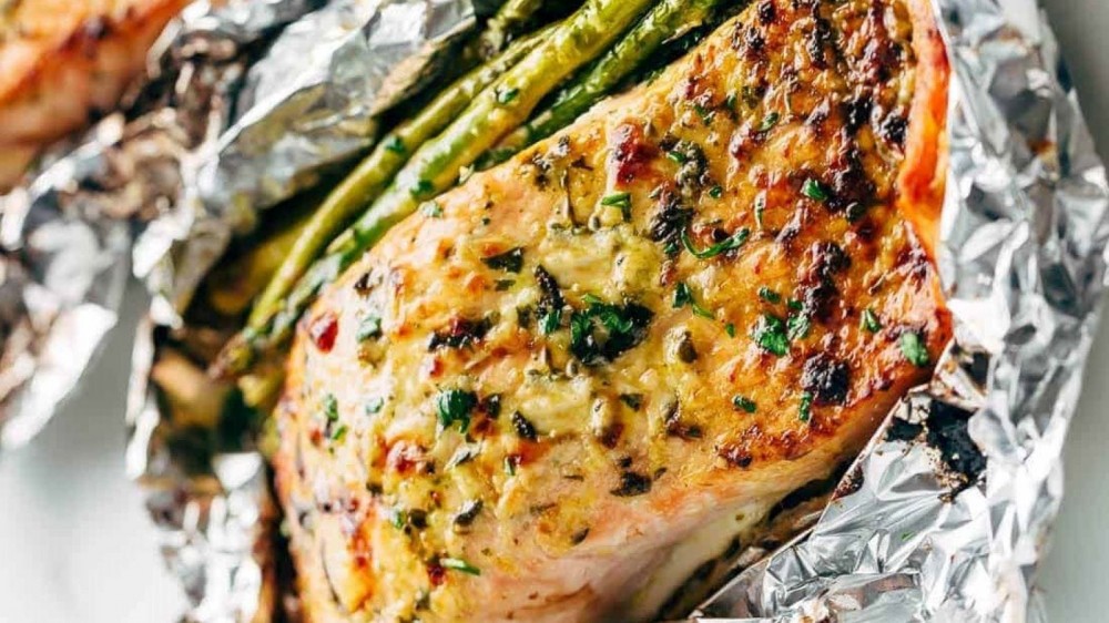 Grilled lemon parmesan salmon and asparagus wrapped in aluminum foil. 