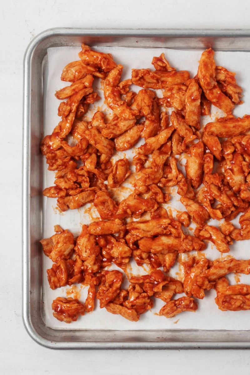 A lined baking sheet has been covered in a plant-based protein.