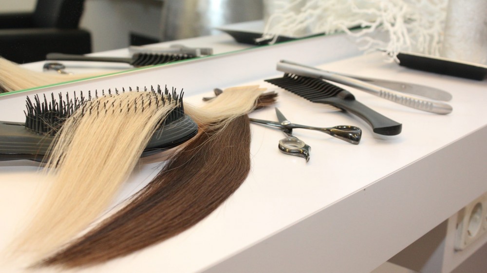 Different extensions with comb and scissors in hair salon.