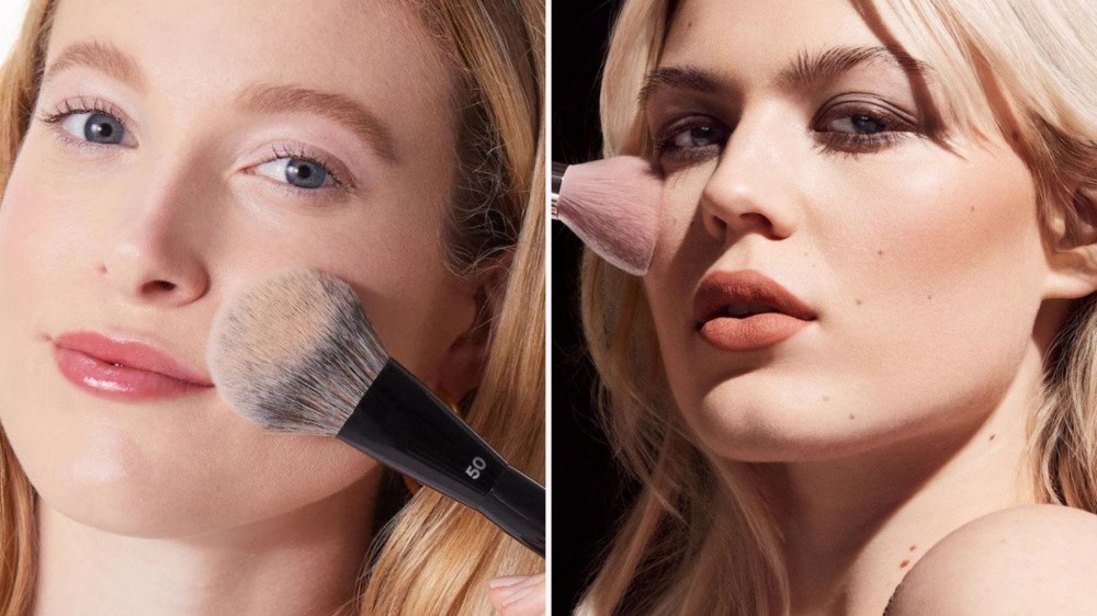 Two white women applying makeup with a puffy brush