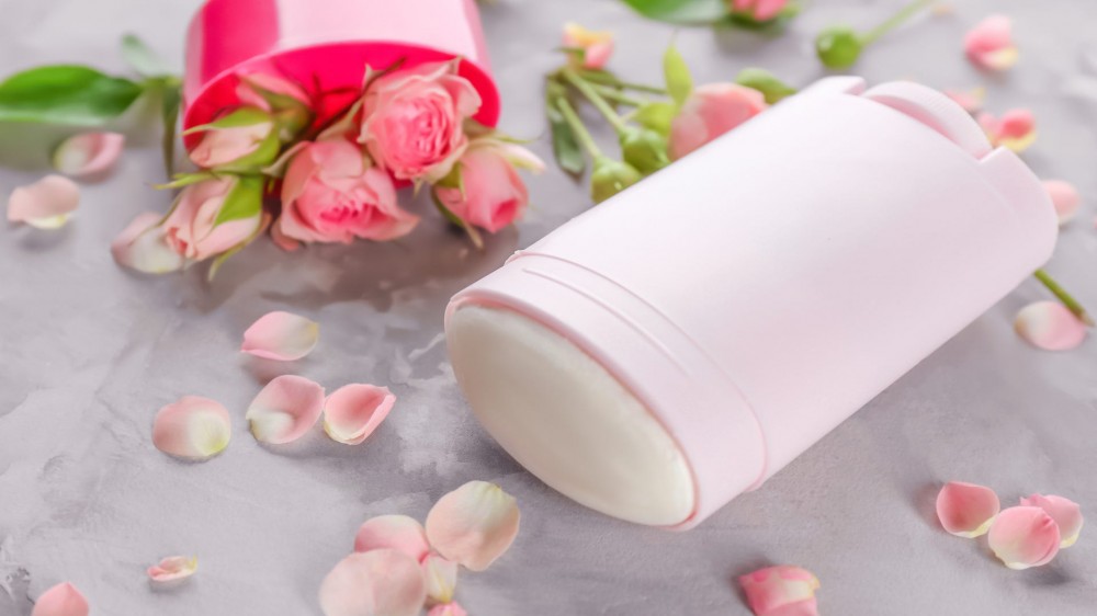 Deodorant for women and flowers on table.