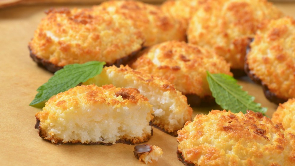 Coconut cookies with mint on a parchment paper.