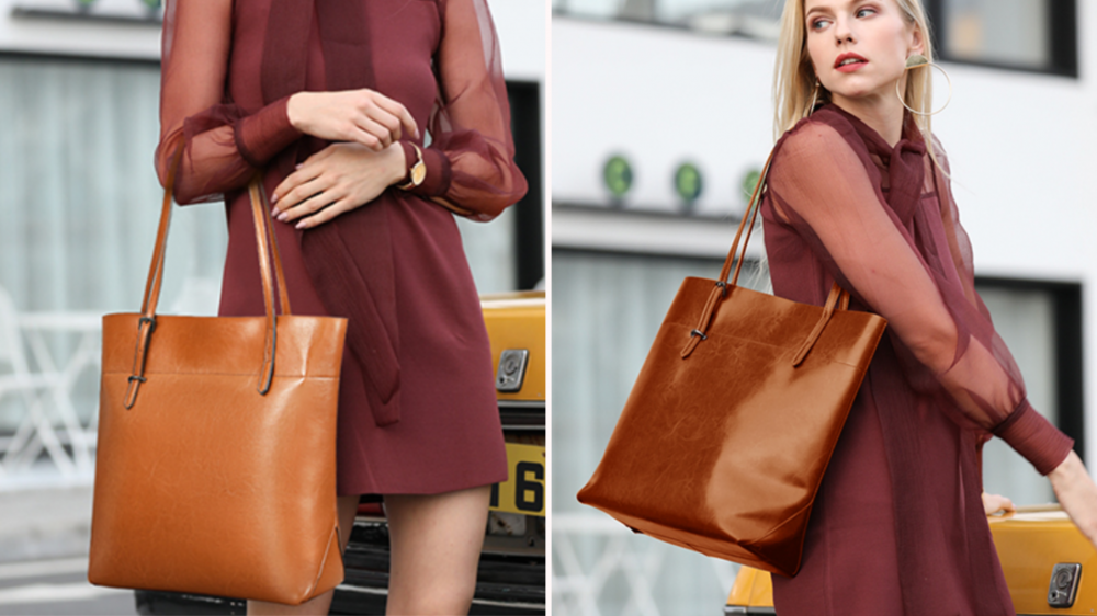 A woman models a brown leather bag over her arm and shoulder.