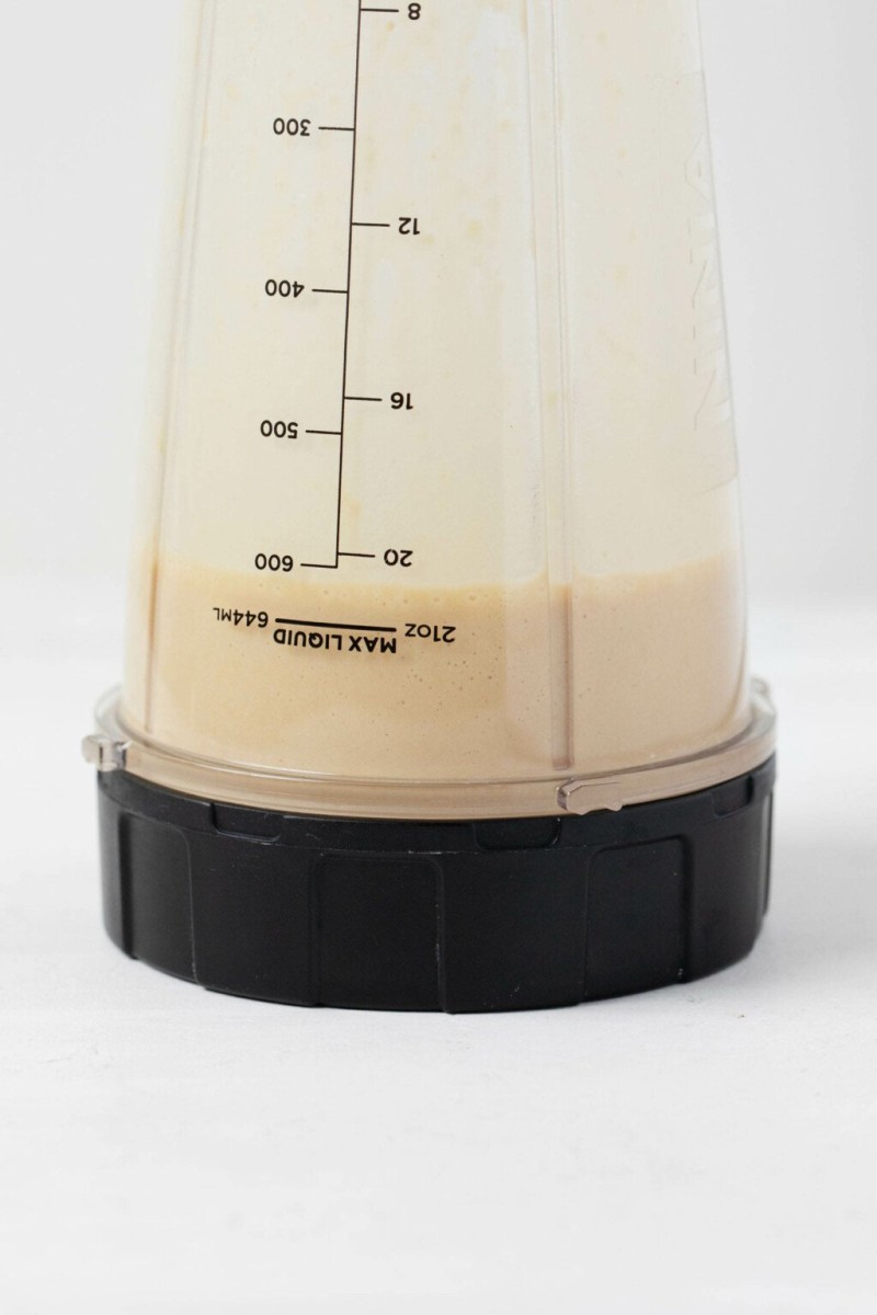 An image of a creamy dressing in the container of a small, personal blender.